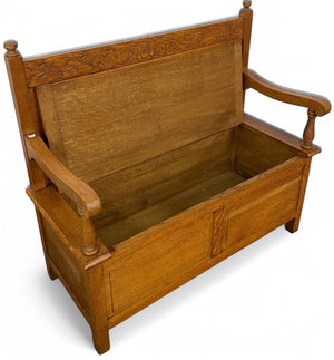 A twentieth century Cotswold style carved oak settle .