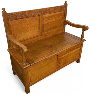 A twentieth century Cotswold style carved oak settle .