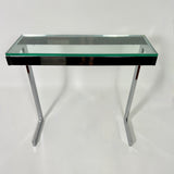 Pair of 1970's modernist chrome console tables with glass tops .