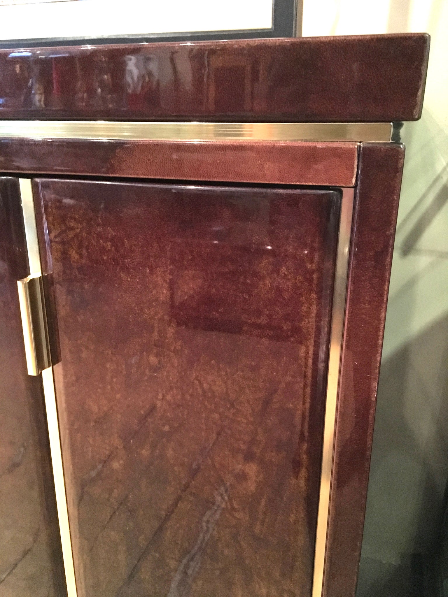 Highly decorative lacquered goatskin sideboard with polished brass details . Italian circa 1970.