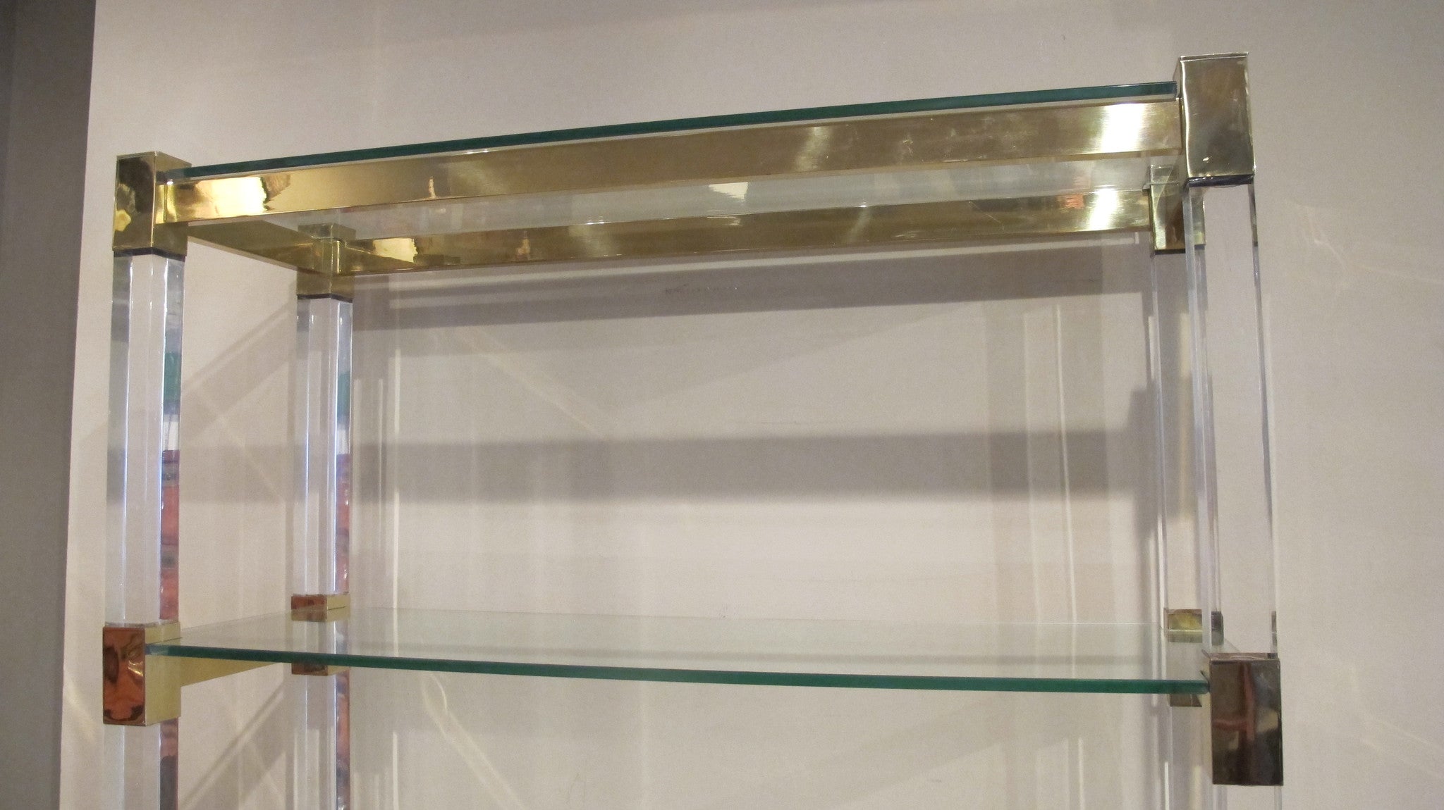 X An impressive perspex shelving unit with 50 mm perspex uprights and heavy gauge bronze frame .