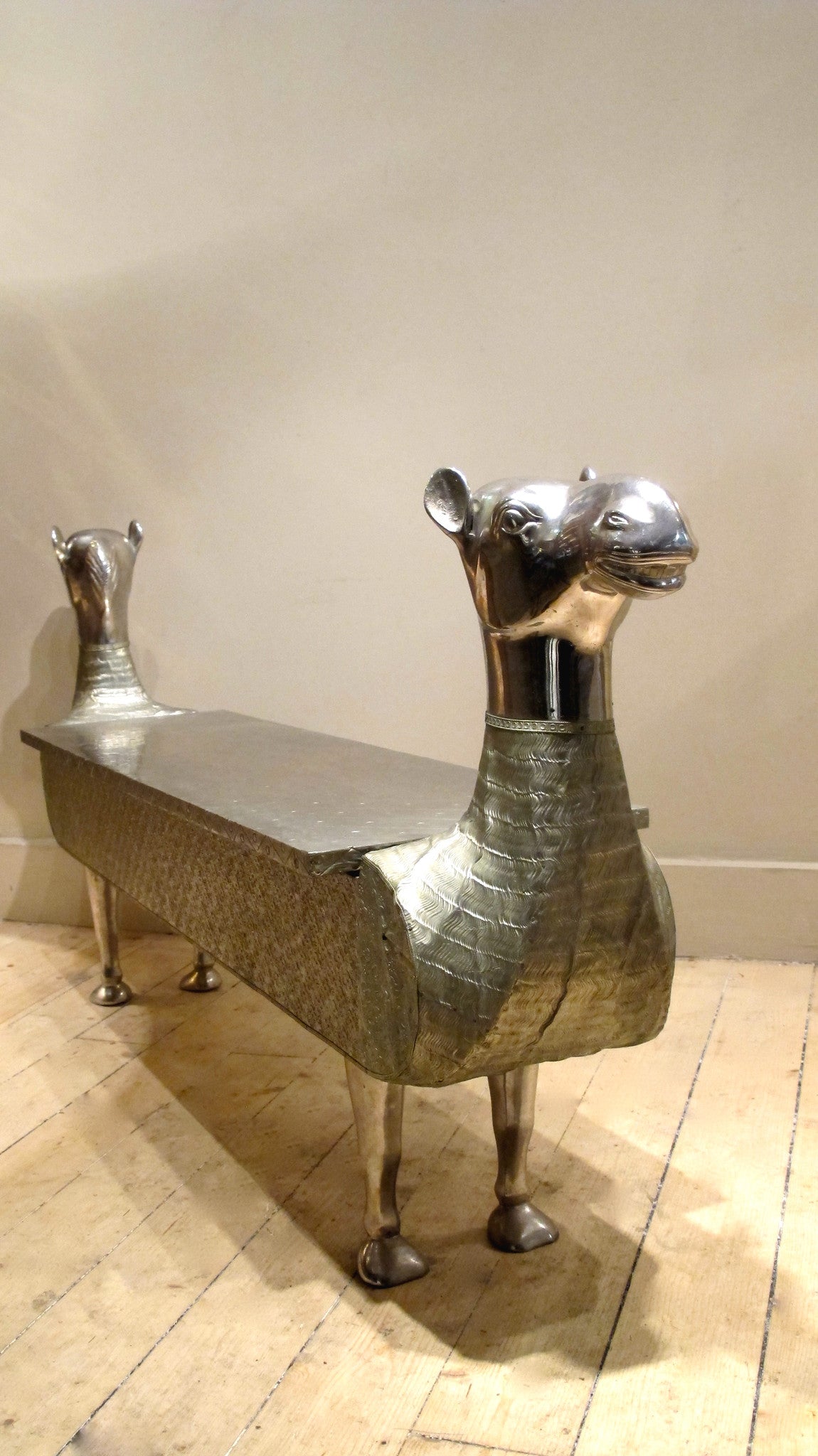 X A fabulous silvered hall bench modelled as a camel with lift up lid and internal storage.Last quarter 20th c.