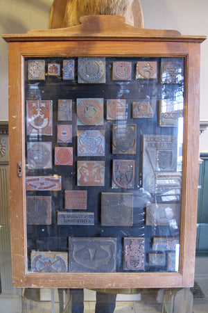 Edwardian printers display of printing blocks in wall mounted mahogany display case.